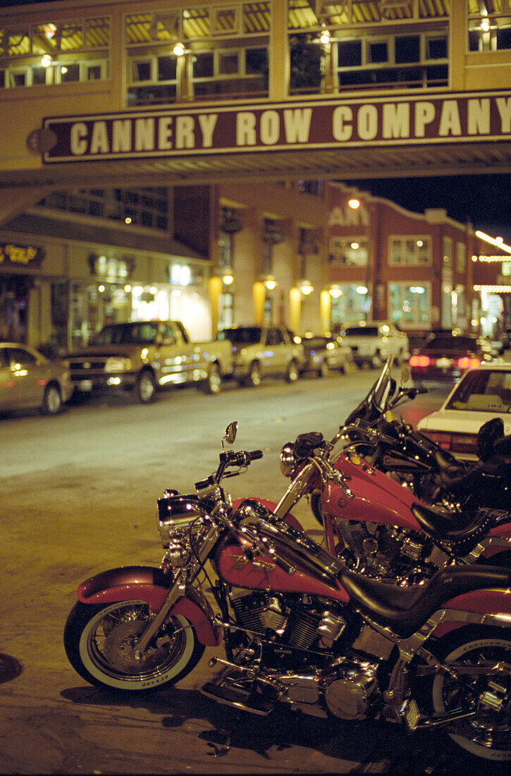 Motorräder und Autos parken in der Cannery Road bei Nacht, Monterey, Kalifornien, USA, Amerika