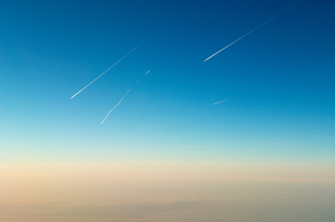 Several Aircraft with contrails overhead horizon