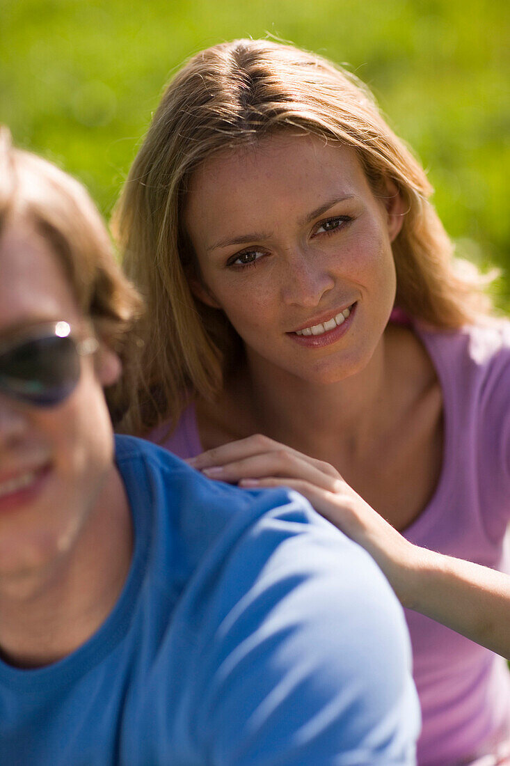 Young couple in nature, woman behind man