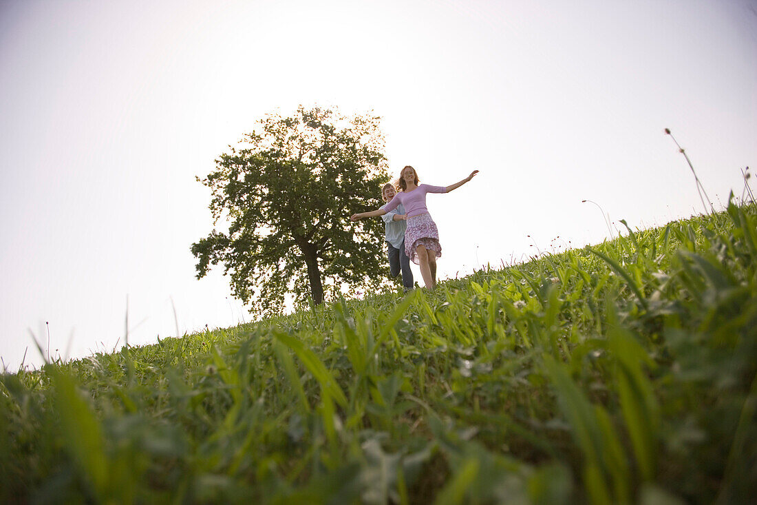 Couple running on meadow