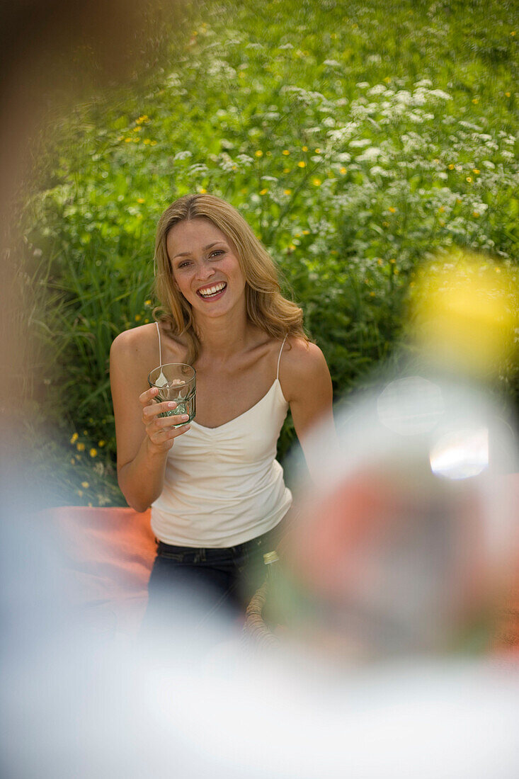 Young woman holding glass, man holding water bottle