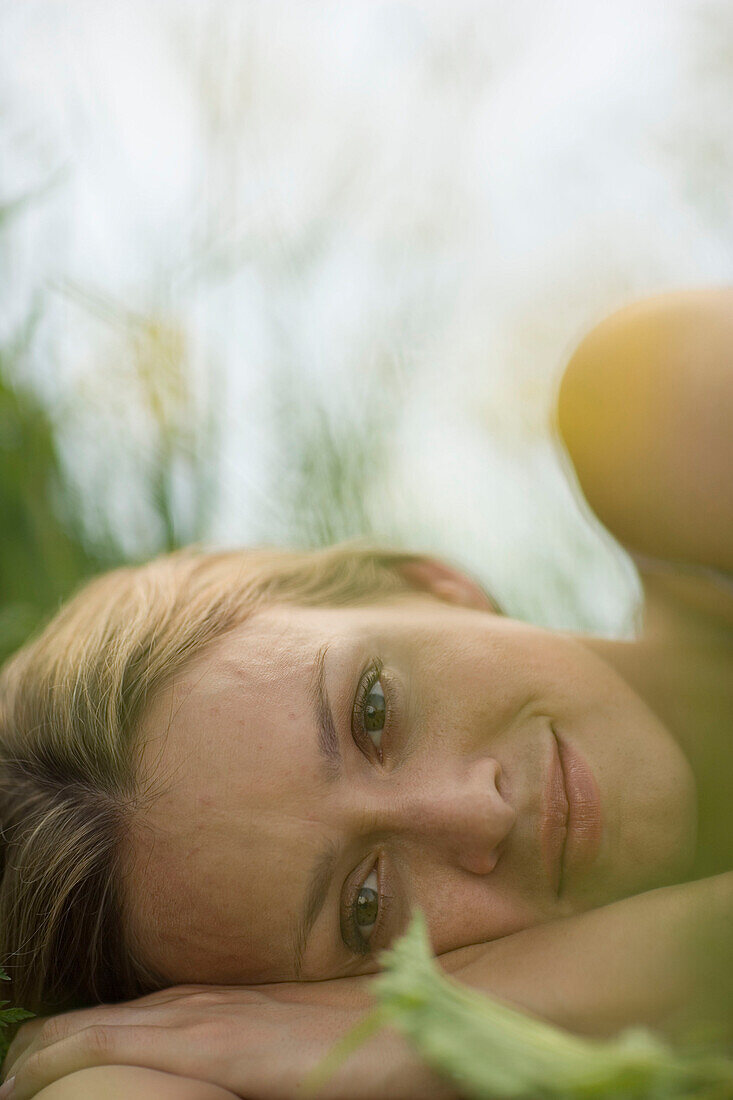 Junge Frau liegt auf einer Wiese, close-up