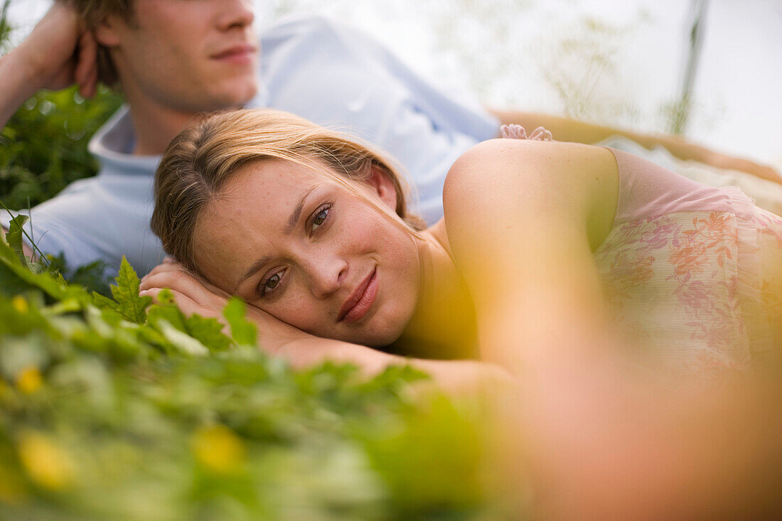 Couple lying in grass, sideview