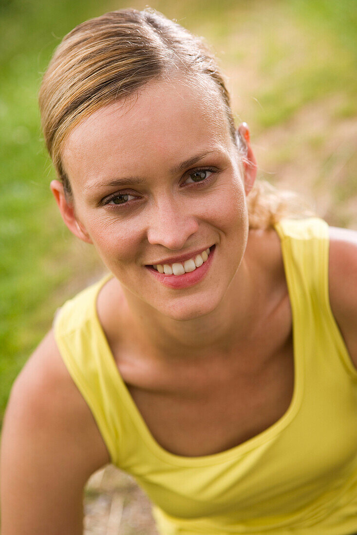 Woman resting while jogging, smiling