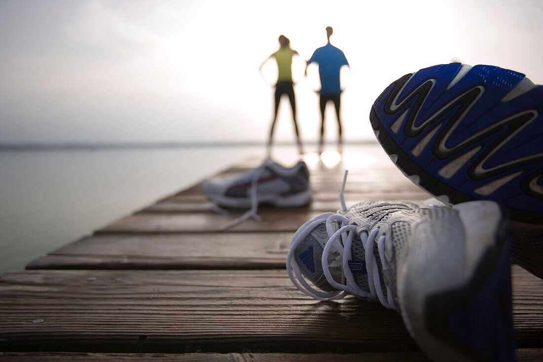 Two people standing on jetty, after jogging