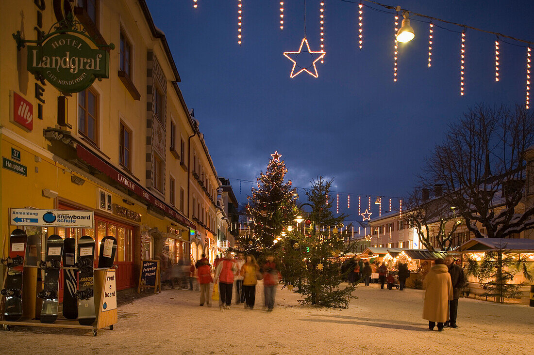 People walking over the christmas market at Hauptplatz in the evening, Schladming, Styria, Austria