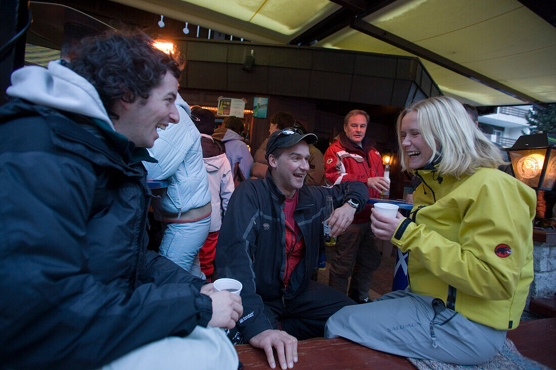 Group of young people enjoying an Apres Ski party on terrace of Papperla Pub, Zermatt, Valais, Switzerland