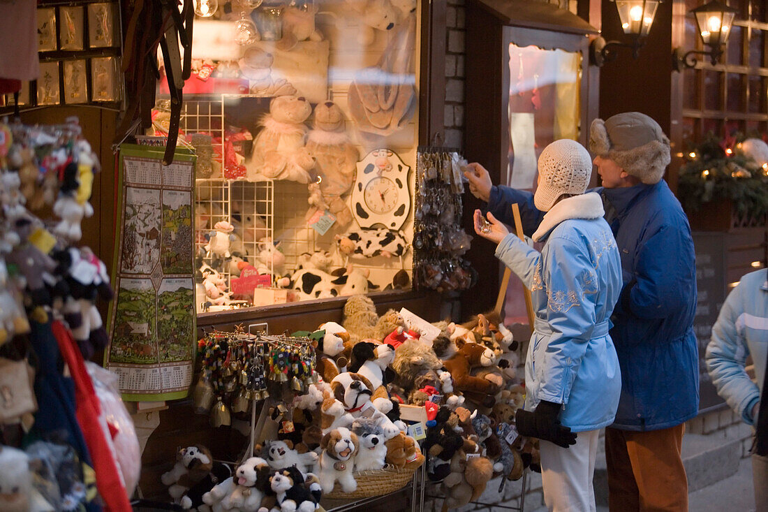 Couple choosing a souvenier in front of a souvenier shop at Bahnhofstrasse, Zermatt, Valais, Switzerland