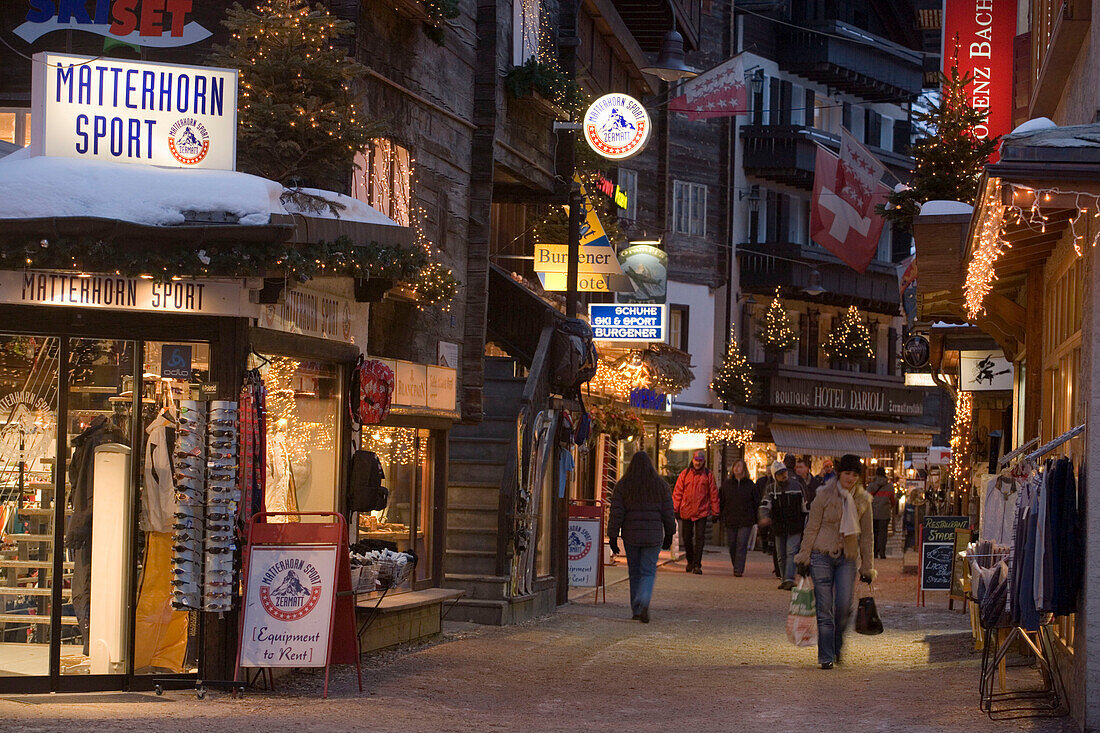 People walking over illuminated shopping street, Zermatt, Valais, Switzerland