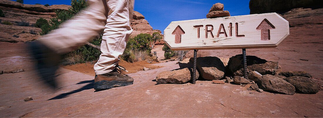 Hiker walking past a trail sign in the Grand Canyon, Utah, USA