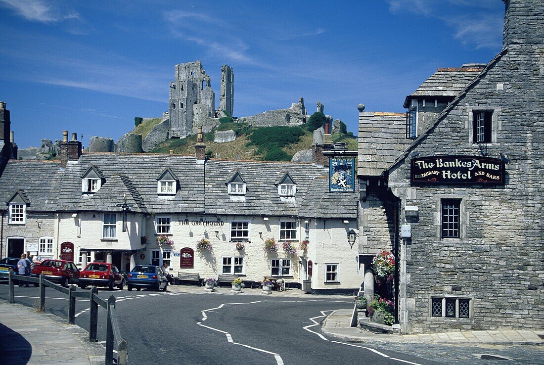 Corfe Castle, viewed with cottages from Corfe village, Isle of Purbeck, Dorset, England