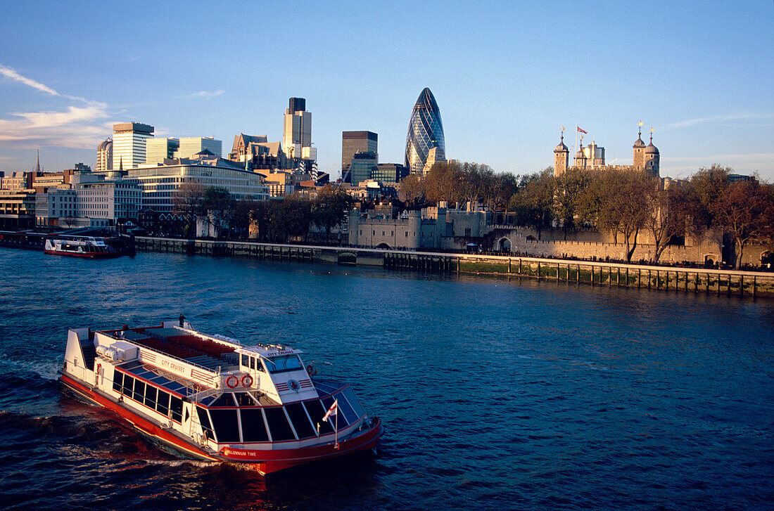 View over River Thames and pleasure boats to the Tower and City of London, including the Swiss Re Building.