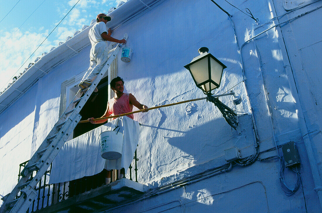 Whitewashing a house in Frigliana,white village,Province Malaga,Andalusia,Spain