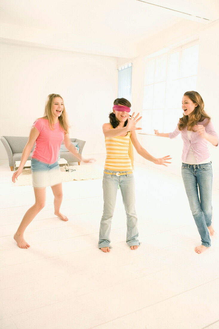 Weibliche Teenager (14-16) spielen Blindekuh