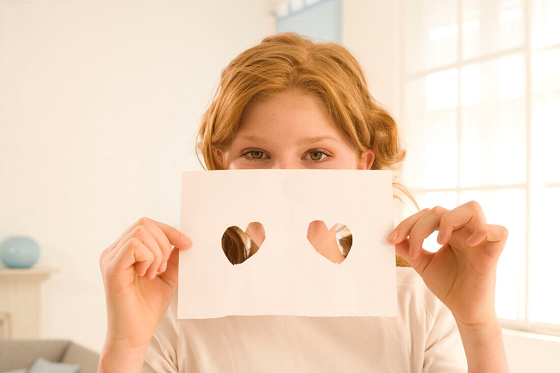 Weiblicher Teenager (14-16) bedeckt Gesicht, Briefbogen mit Herzen