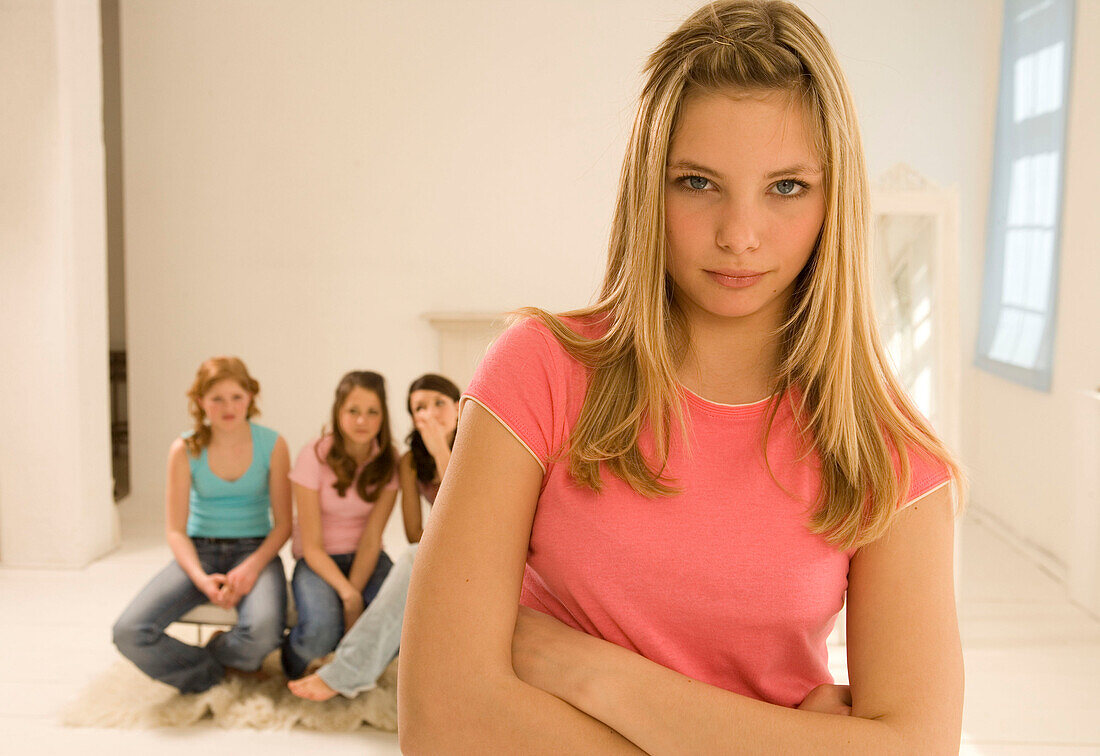 Teenage girl (14-16) standing out from other girls, bullying