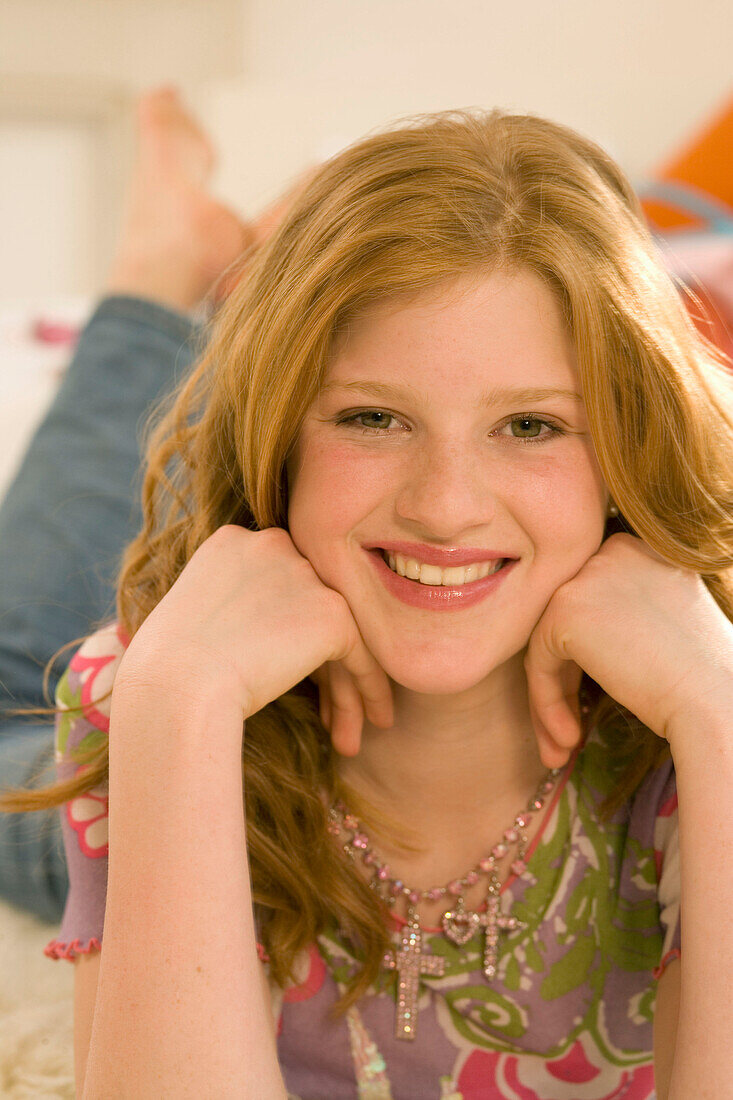 Teenager, Mädchen (14-16) liegt auf Felldecke, lächelt