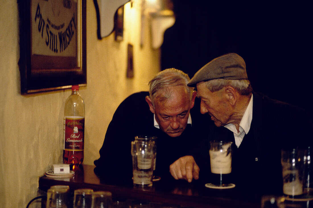 Zwei alte Männer diskutieren an der Theke, County Mayo, Irland