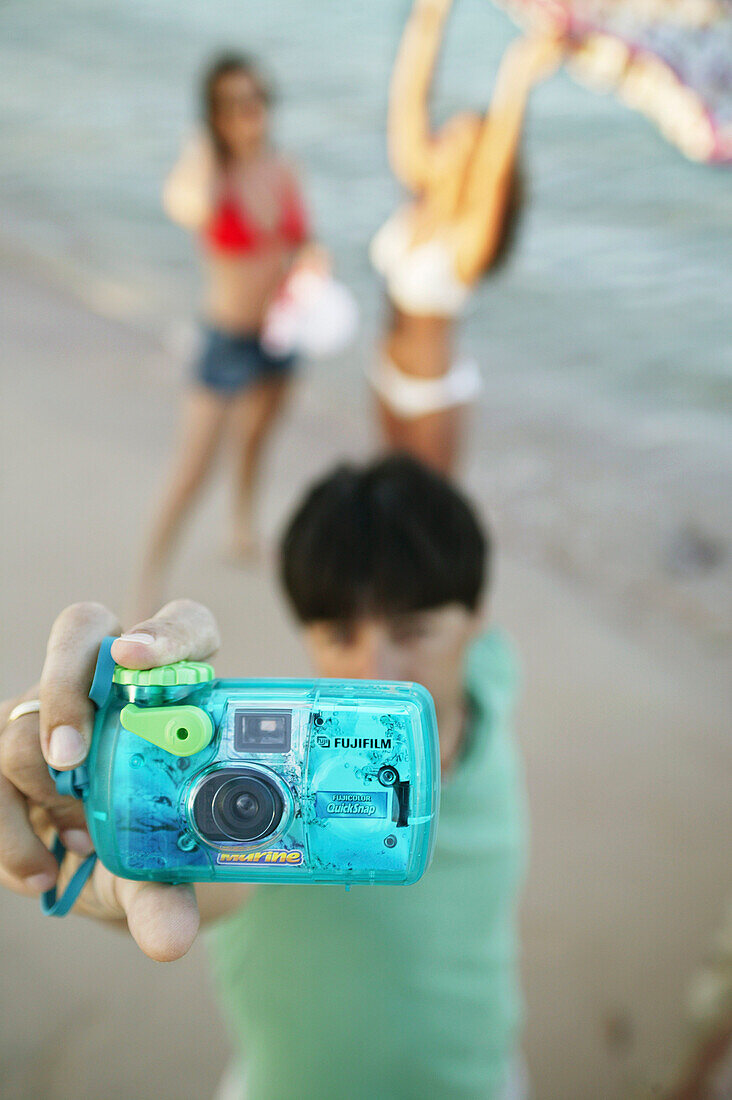 Young man taking a picture by a digital camera