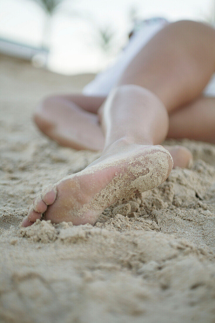 Low section view of a woman, lying down on the beach
