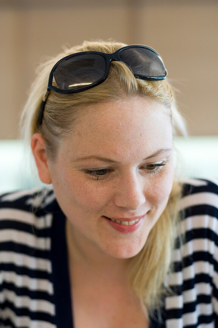 Blond woman wearing fasciated top, portrait