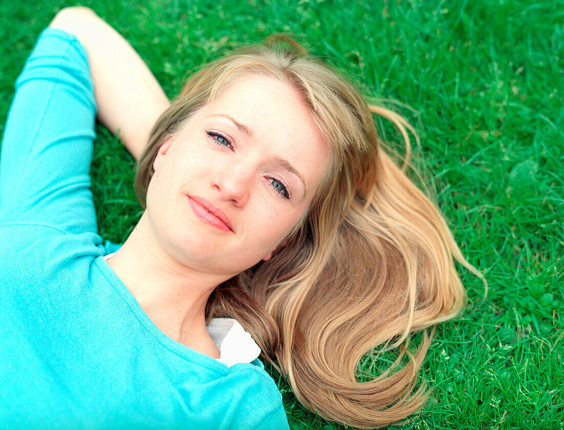 Young woman lying on grass