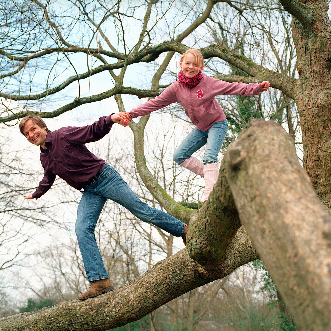 Vater und Kind klettern im Baum, Deutschland, Deutsche, Tochter, Erziehung, aufwachsen, spielen, toben, lernen, Spass, lachen, Freude, Abenteuer, Hand in Hand, Führung, laufen auf Ast, Zusammenhalt, gemeinsam, Familie, Freizeit