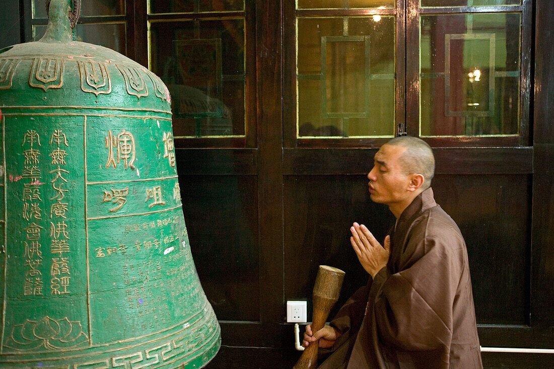 Mönch betet vor Bronzeglocke, Wannian Kloster, Berg Emei Shan, Provinz Sichuan, China, Asien