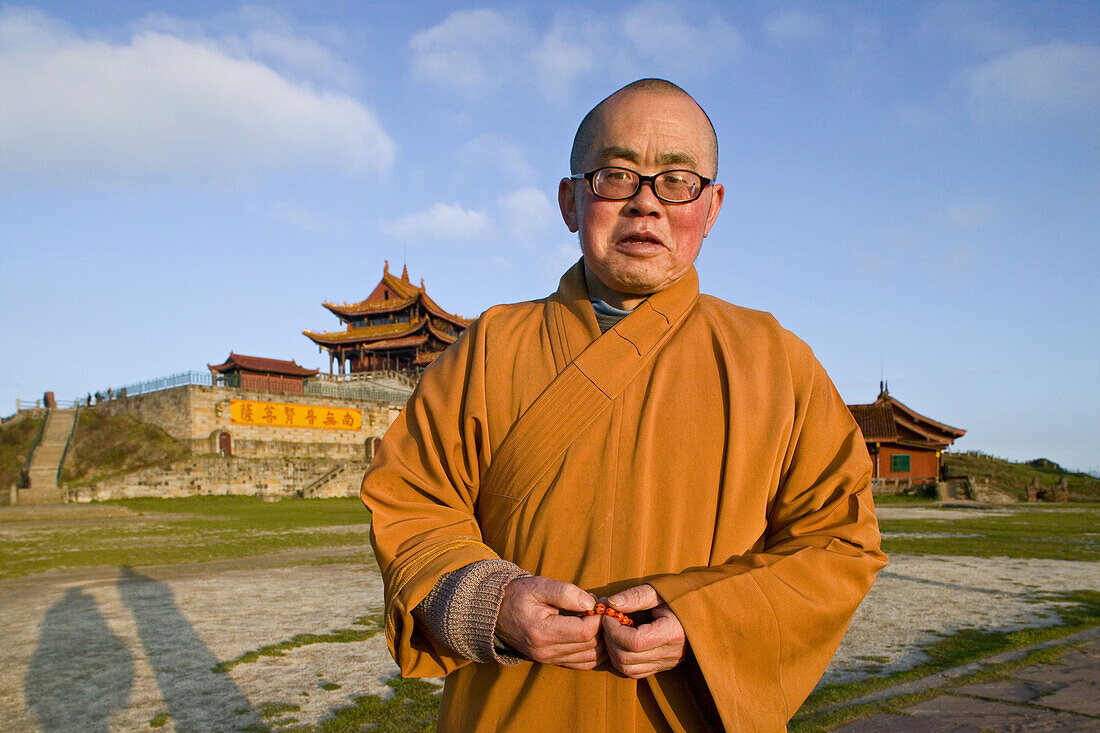 A monk standing in front of the Huazang monastery on the summit of Emei Shan mountains, Sichuan province, China, Asia