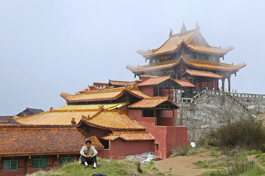 A person sitting in front of Huazang Monastery, Emei Shan mountains, Sichuan province, China, Asia