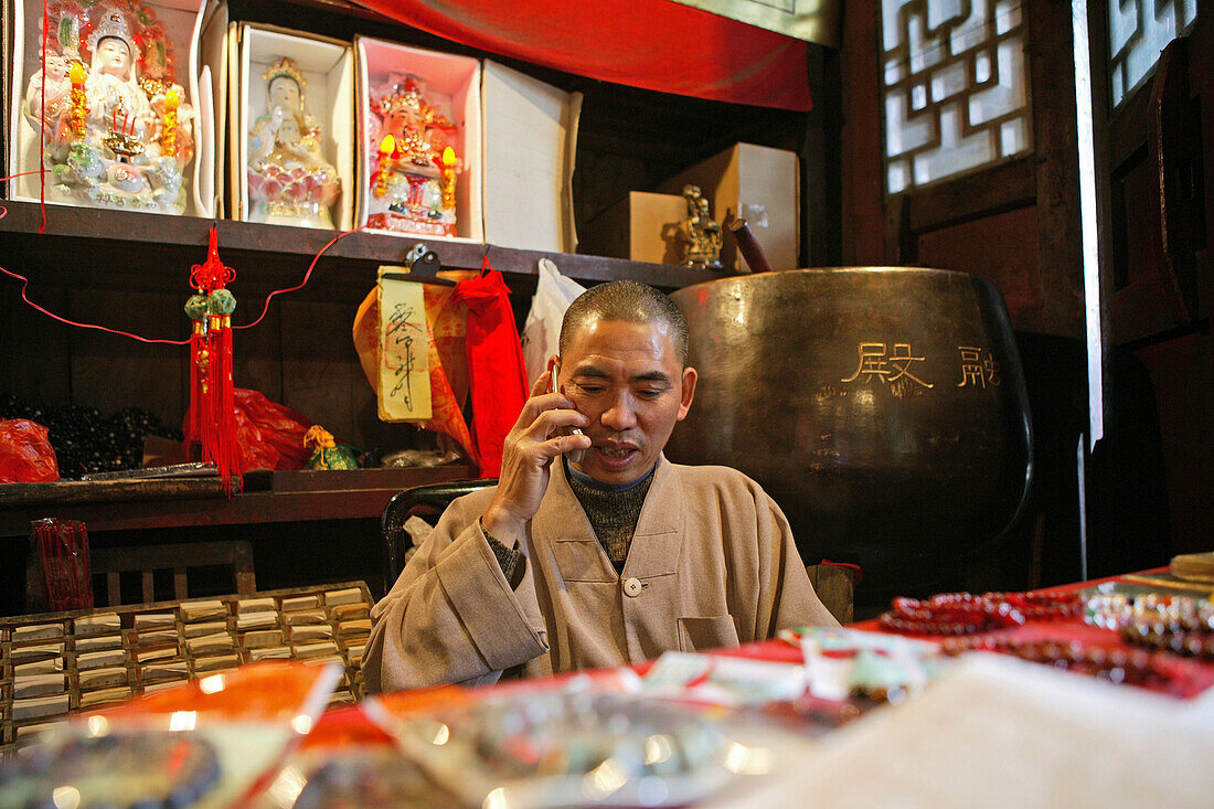 Monk with mobile phone at the entrance of temple, Zhu Rong Feng, Heng Shan South, Hunan province, China, Asia