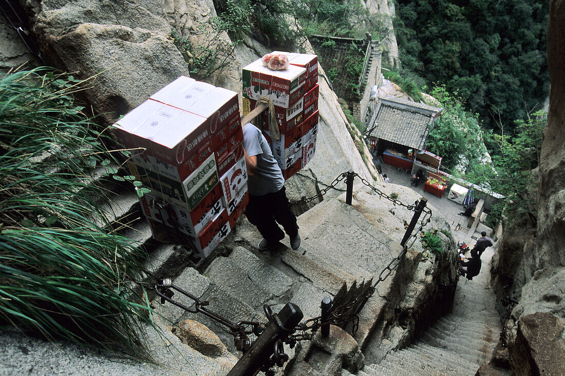 porters carry furniture, food and building materials on their backs up steep mountain steps, Taoist mountain,  Hua Shan, Shaanxi province, Taoist mountain, China, Asia