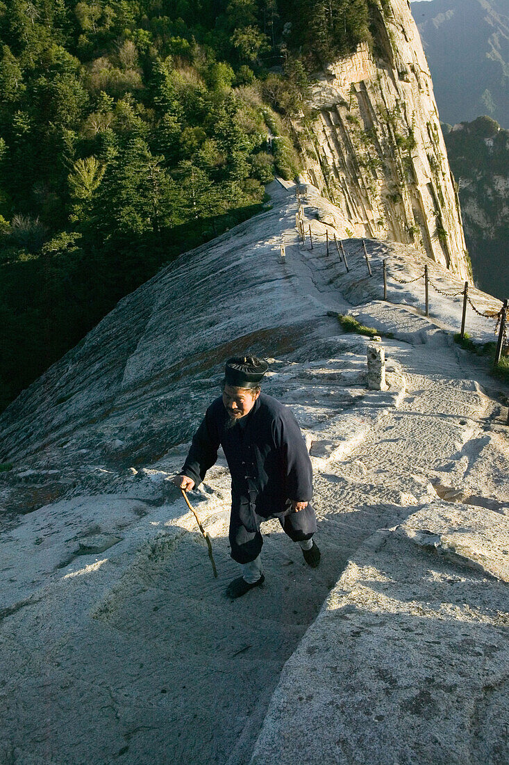 Mönch, Südgipfel, Hua Shan,taoistischer Mönch wandert auf dem Fischrückengrat zum Kloster Cui Yun Gong, Südgipfel, Huashan, Steilwand des Westgipfels, Provinz Shaanxi, China, Asien