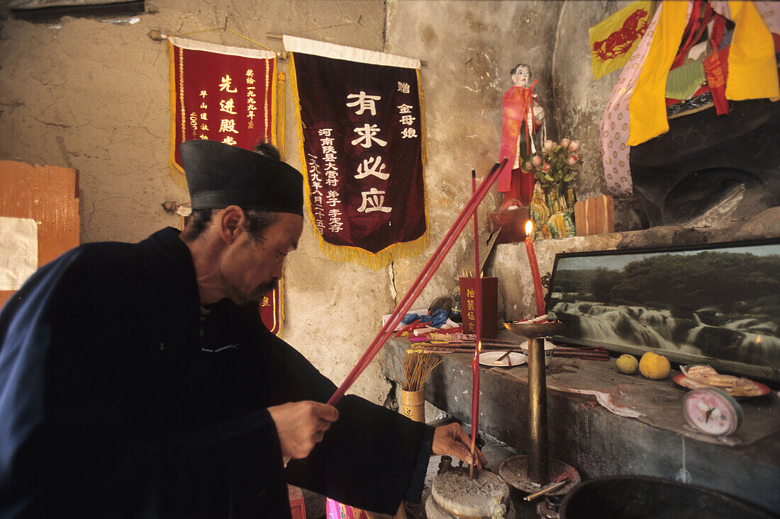 Einsiedler, Mönch, Hua Shan,Einsiedlermönch, Daoist im Gebet in seinem kleinen Tempel, Höhlentempel in einer Steilwand, Huashan, Provinz Shaanxi, China, Asien
