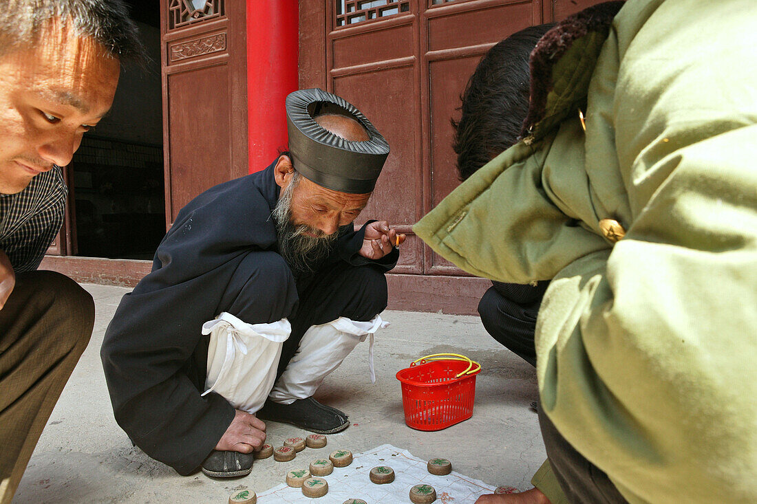 Abbot playing chinese chess at the courtyard of Cui Yun Gong monastery, Hua Shan, Shaanxi province, China, Asia