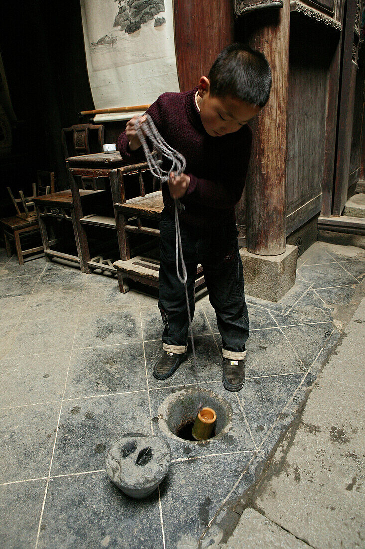 Junge schöpft Wasser aus dem Hausbrunnen, Hongcun, Huang Shan, China, Asien