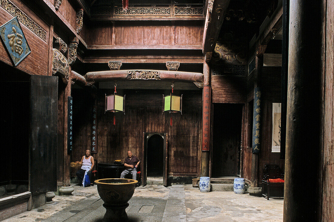 Zwei Männer sitzen im traditionellen Innenhof eines Hauses im Dorf Hongcun, Huang Shan, China, Asien