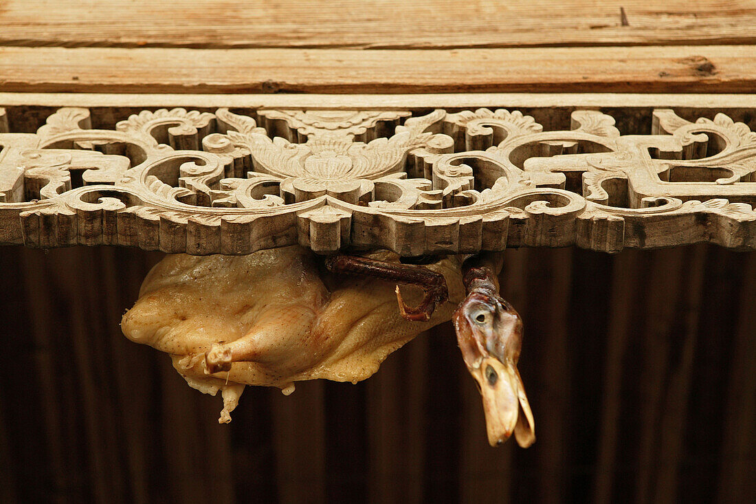 Kunstvolle Schnitzereien und getrocknete Ente am Dachbalken eines Hauses im Dorf Hongcun, Huang Shan, China, Asien