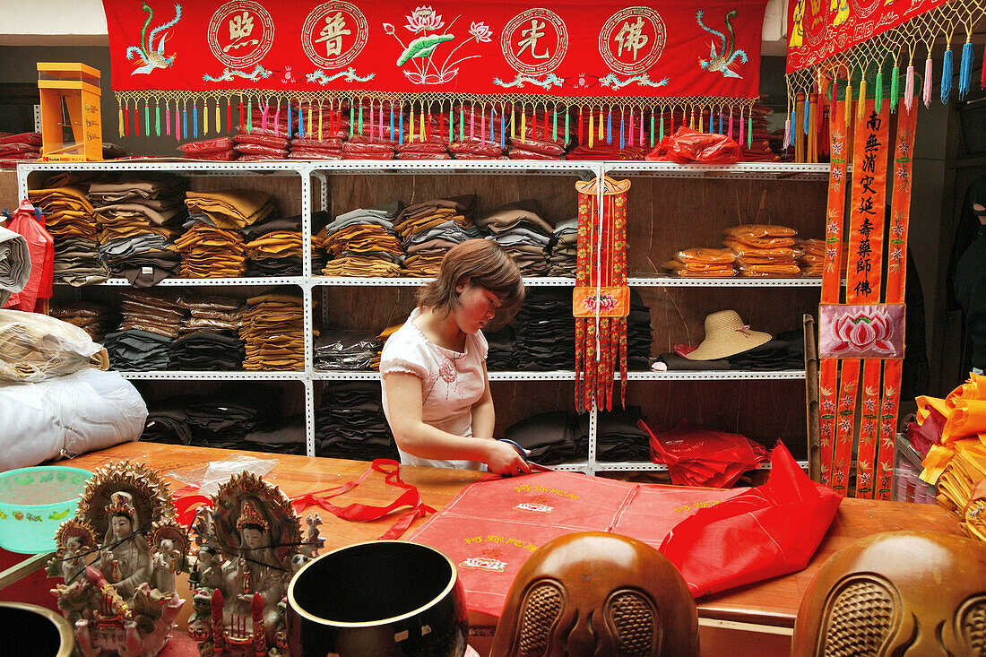 Eine Frau arbeitet in einer Schneiderei für Mönchskleidung, Jiuhuashan, Provinz Anhui, China, Asien