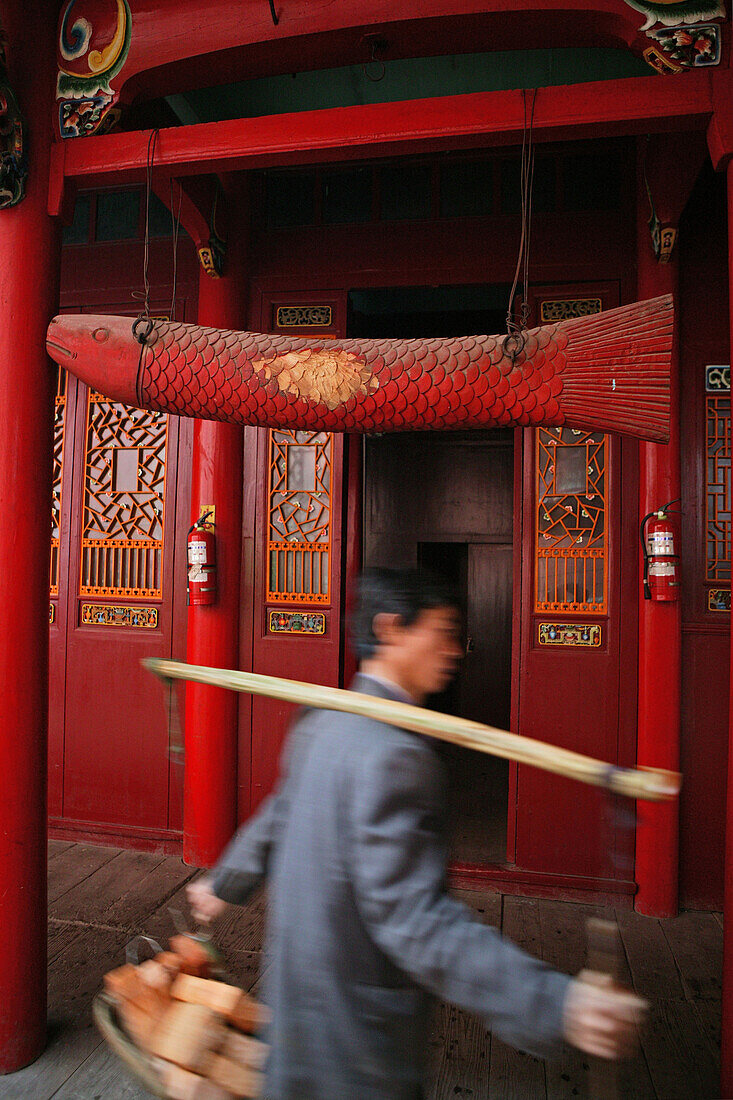 Träger mit Baumaterial und Holzfisch vor Qiyuan Kloster, Jiuhuashan, Provinz Anhui, China, Asien