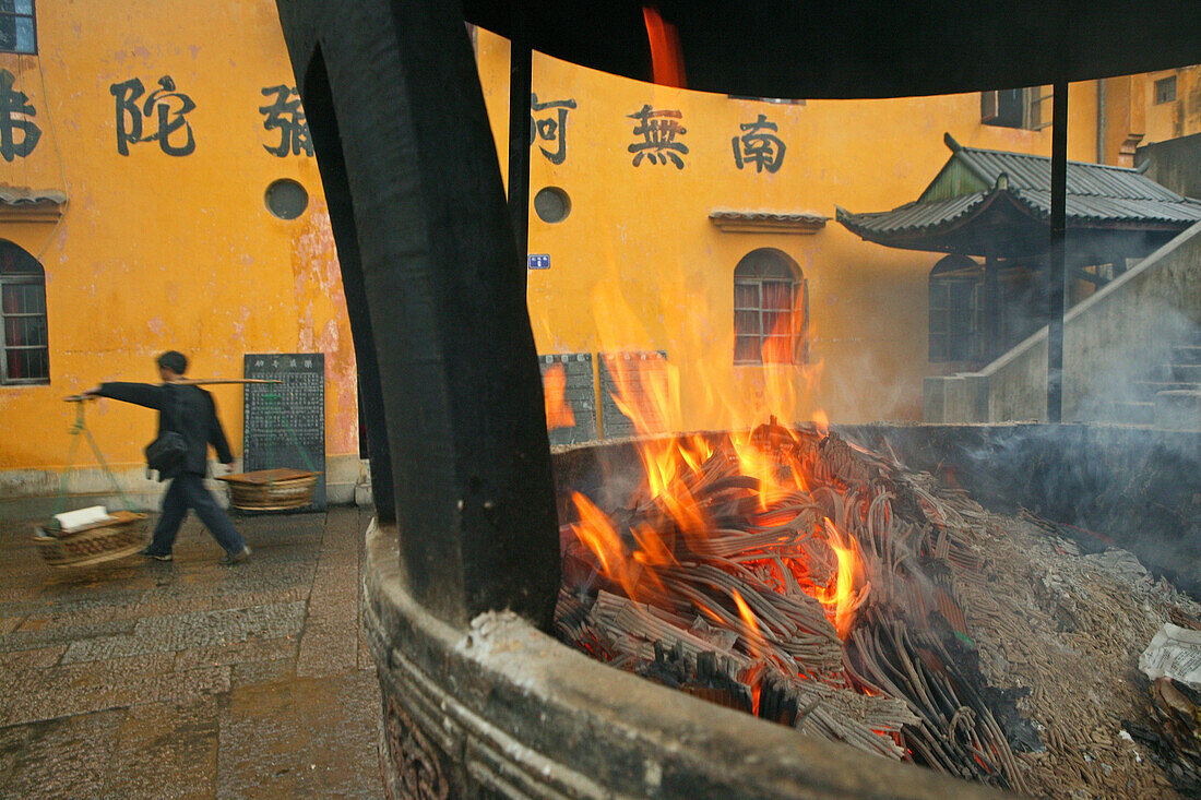 Tianchi Kloster, Jiuhua Shan ,Träger vor dem Tianchi Kloster, Dorf Minyuan, Feuerkessel für Räucherwerk, Räucherstab, gelbe Fassade mit Kalligrafie, Bodhisattva ksitigarbha, Jiuhua Shan Mountains, Provinz Anhui, China, Asien