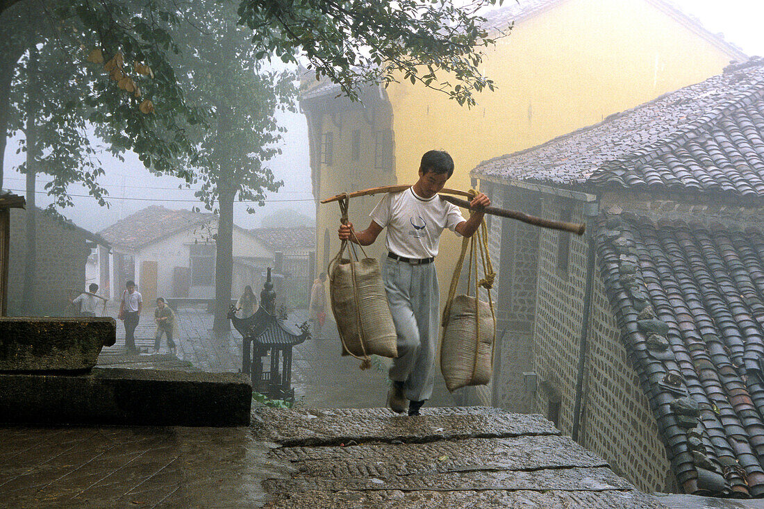 Träger mit Baumaterial vor dem Tianchi Kloster im Dorf Minyuan, Jiuhuashan, Provinz Anhui, China, Asien