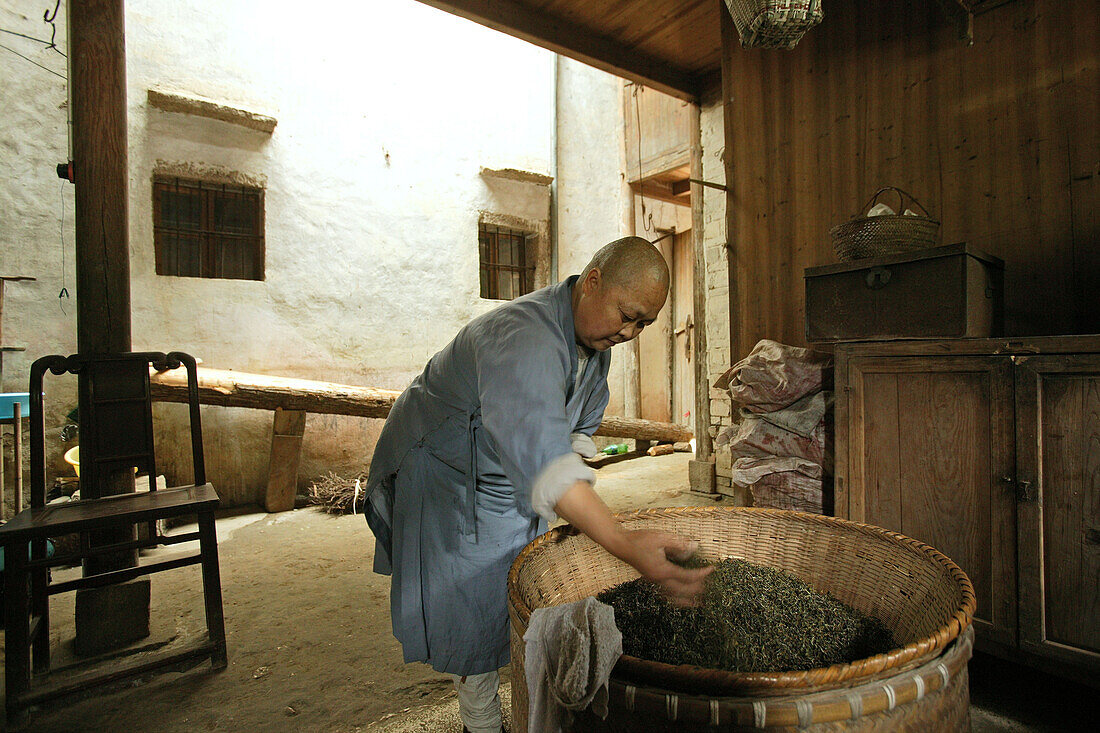 Eine Nonne trocknet Teeblätter, Nonnenkloster im Dorf Minyuan, Jiuhua Shan, Provinz Anhui, China, Asien