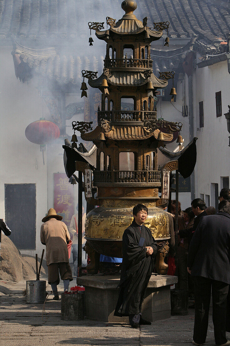 People standing at incense pagoda in front of Longevity monastery, Jiuhua Shan, Anhui province, China, Asia