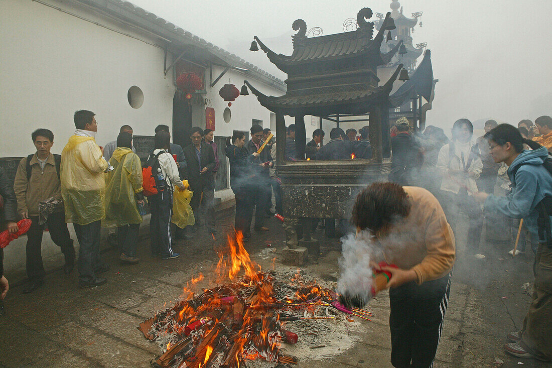 Pilger verbrennen Räucherstäbe vor dem Longevity Kloster, Jiuhua Shan, Provinz Anhui, China, Asien