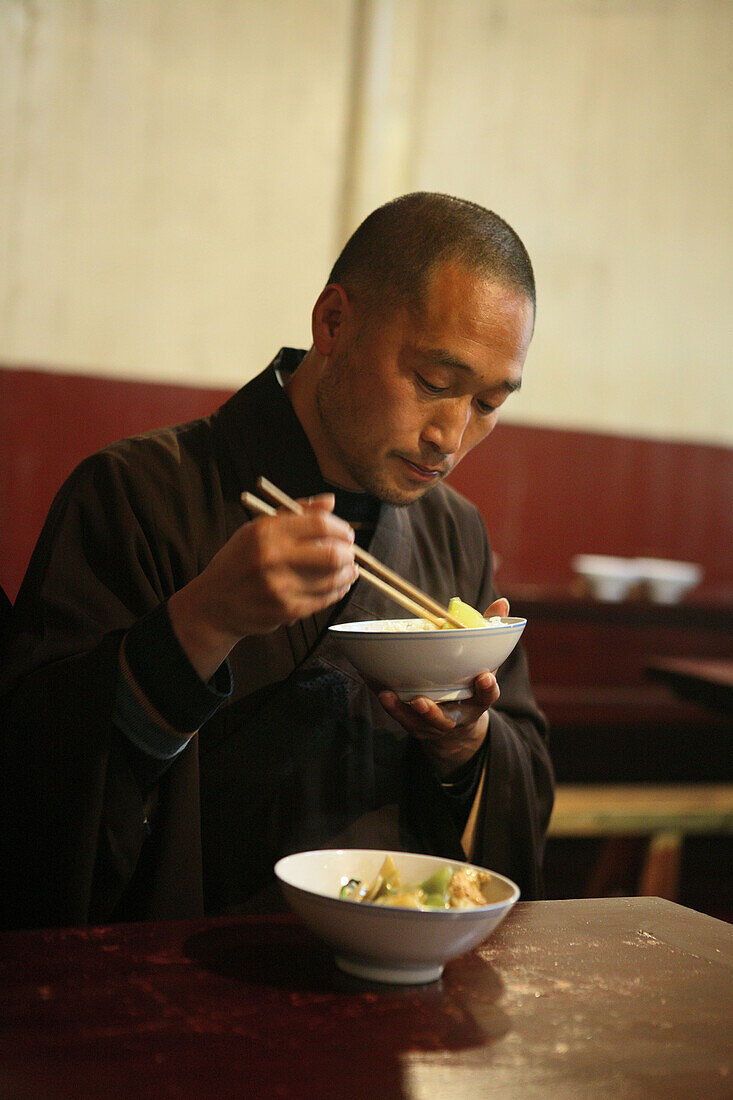 monk with bowl of rice, dining room, Longevity Monastery, Jiuhuashan, Mount Jiuhua, mountain of nine flowers, Jiuhua Shan, Anhui province, China, Asia