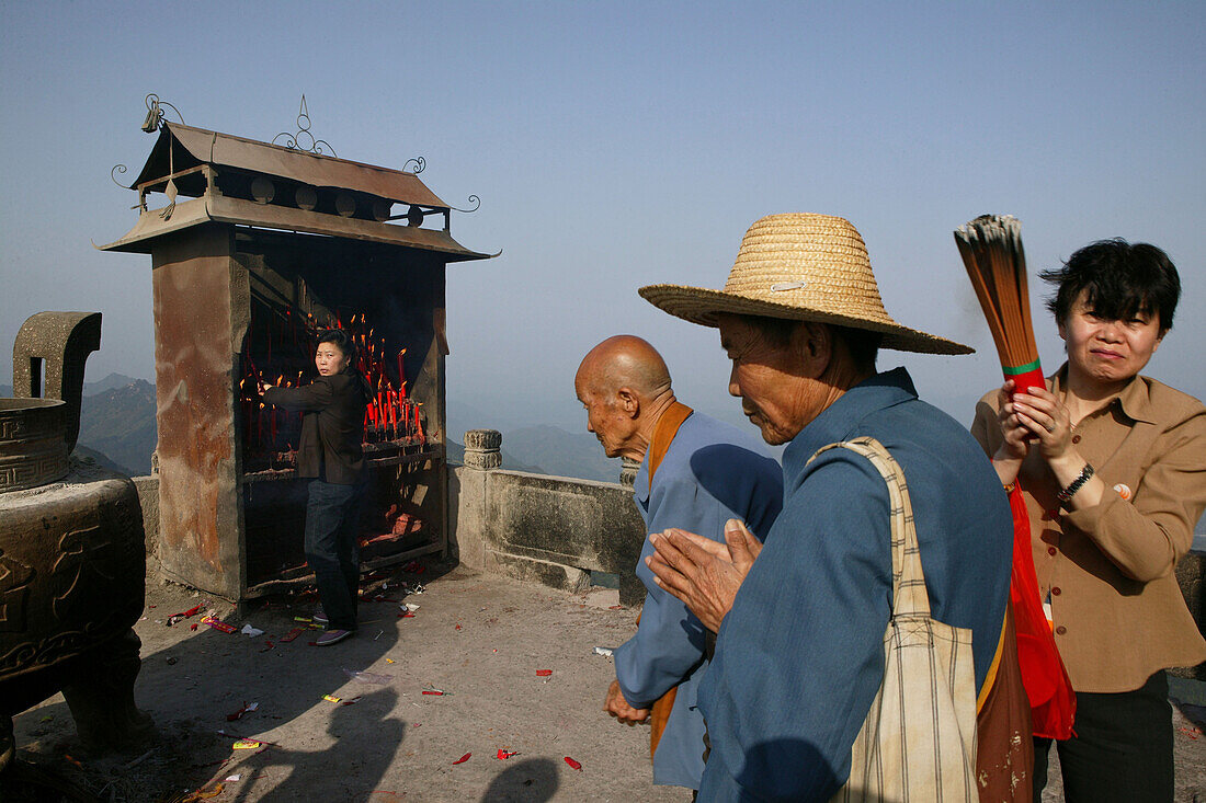 Pilger verbrennen Räucherstäbe auf einem Berggipfel am Kloster Tian Tai Feng, Jiuhua Shan, Provinz Anhui, China, Asien