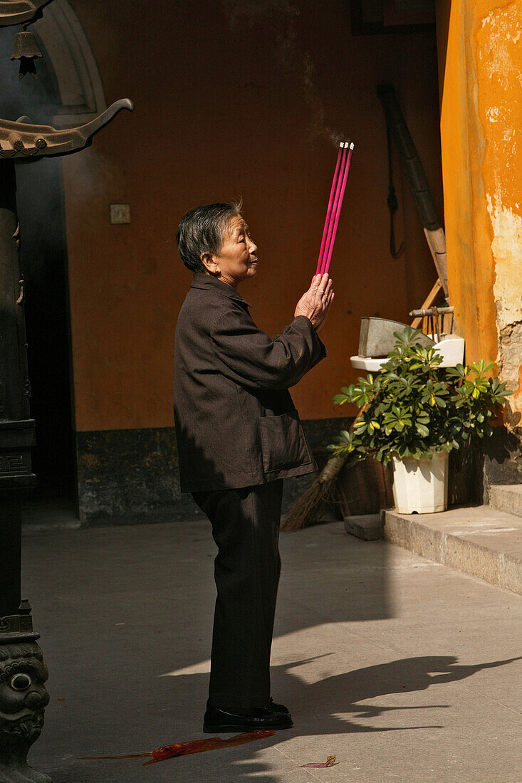 Betende Frau hält Räucherstäbe, Putuo Shan, Provinz Zhejiang, China, Asien