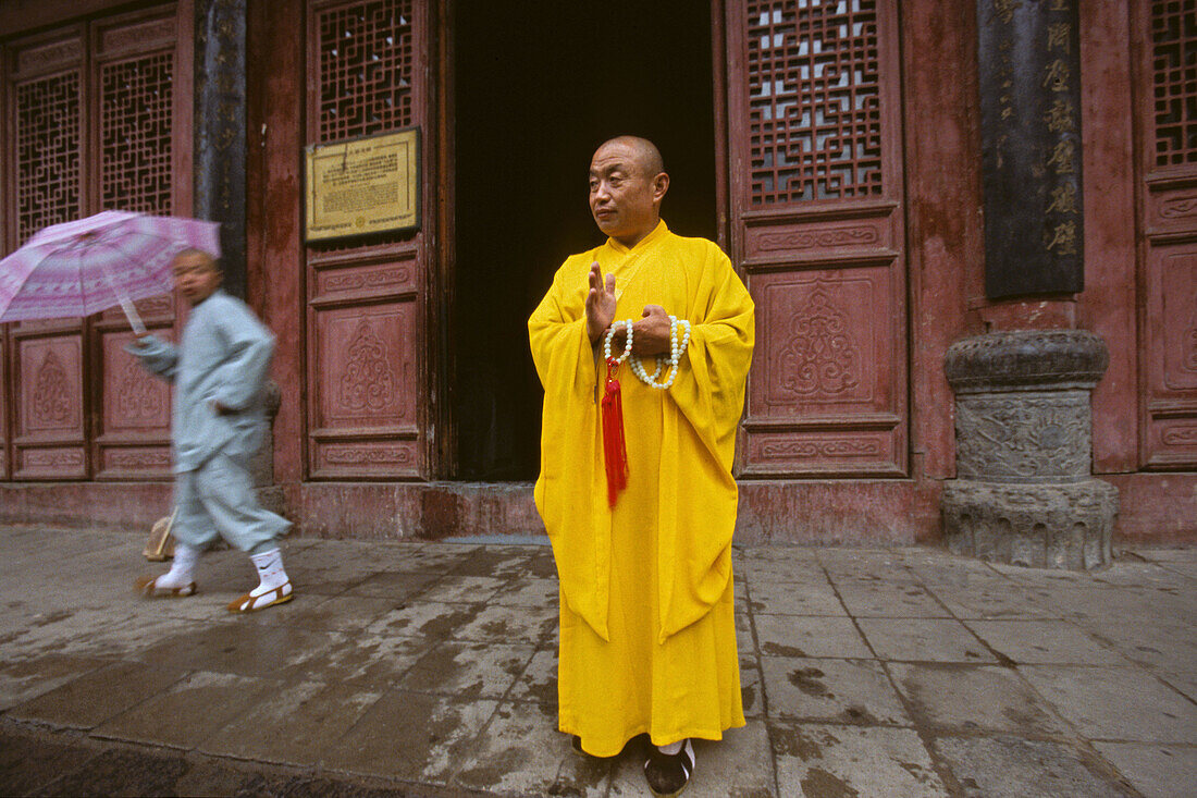 Shaolin monk leaving the temple after prayer, Shaolin Monastery, known for Shaolin boxing, Taoist Buddhist mountain, Song Shan, Henan province, China