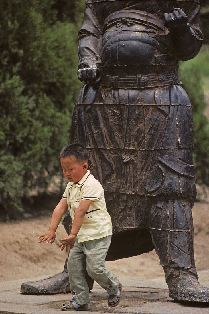 Wächterstatuen, Song Shan,Kind vor Tempelwächter aus Gußeisen im im Vorhof des Kloster Zhongyue, taoistischer Tempel,  Zhongyue, daoistisch-buddhistischer Berg Song Shan, Provinz Henan, China, Asien